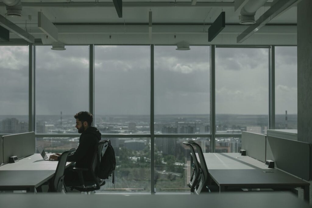 A Man in Black Jacket Sitting on Chair Working in the Office